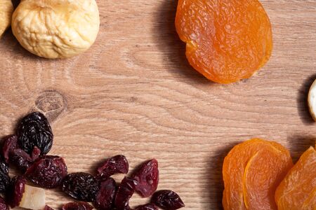 Different type of dried fruits on wooden background in studio photoの写真素材