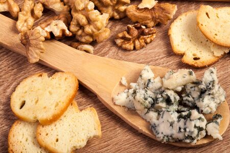 Crackers, white cheese and honey on wooden background in studio photoの写真素材