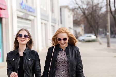 Two female friends having fun outside in the city. Friendship and urban lifestyleの写真素材
