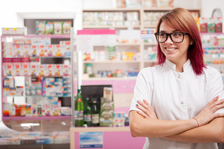 Smiling pharmacist in glasses in front of her desk at work. Healhtcare businessの写真素材