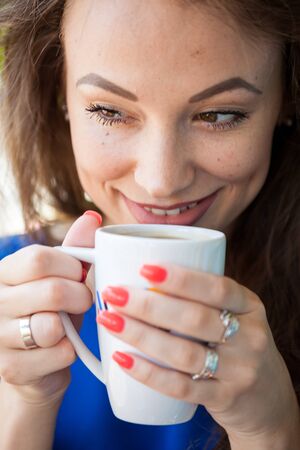 Beautiful young woman drinking a cup of coffee. Coffee drinker.の写真素材