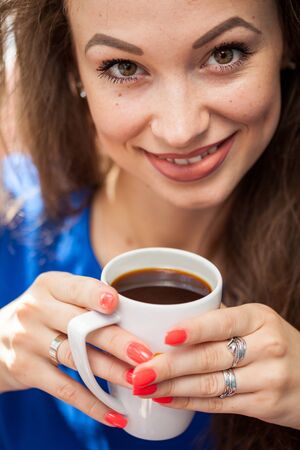 Beautiful smiling woman drinking a cup of coffee. Coffee drinker.の写真素材