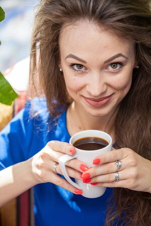 Pretty woman drinking coffee at a terraceの写真素材