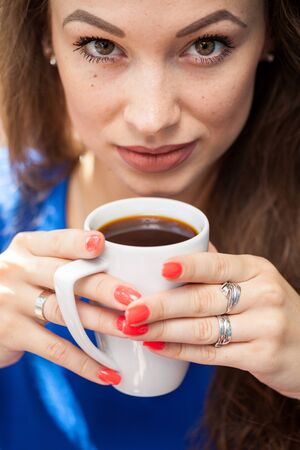 Gorgeous young woman drinking a cup of coffee. Coffee drinker.の写真素材