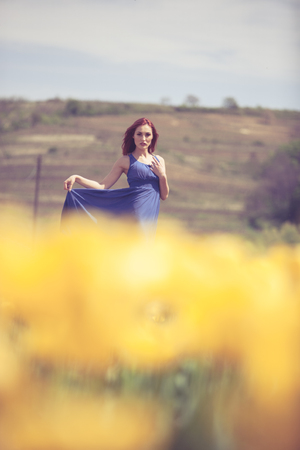 Beautiful woman in flower field in sunny day. Outdoor shooting. Lifestyle and relaxationの写真素材
