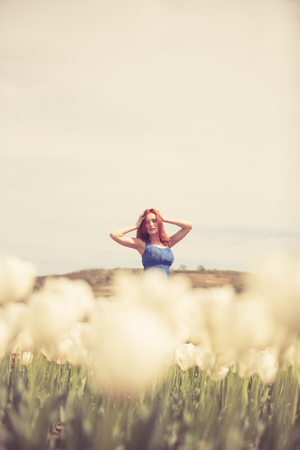 Gorgeous woman in blue dress in tulips field. Outdoor shooting. Lifestyle and relaxationの写真素材