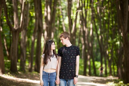 Beautiful couple taking a walk in the forest. Lifestyle and relationship. Young inlove boyfriend and girlfriendの写真素材