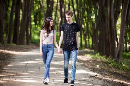 Inlove couple taking a walk in the forest. Lifestyle and relationship. Young inlove boyfriend and girlfriendの写真素材