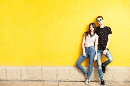 Couple posing in fashion style on yellow wall. Lifestyle and relationshipの写真素材