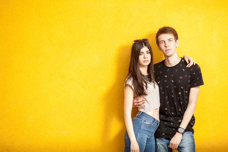 Inlove couple posing in fashion style on yellow wall. Lifestyle and relationshipの写真素材