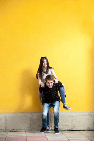 Happy couple posing in fashion style on yellow wall. Lifestyle and relationshipの写真素材