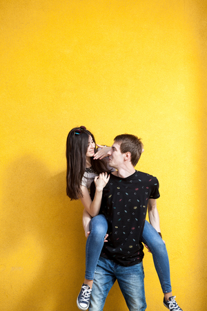 Cool young couple posing in fashion style on yellow wall. Lifestyle and relationshipの写真素材