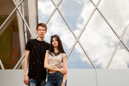 Young couple posing in fashion style in front of glass office buildingの写真素材