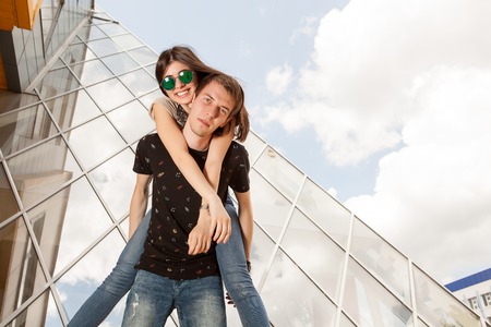 Happy couple posing in fashion style in front of glass office buildingの写真素材