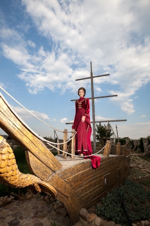 Beautiful woman in vintage clothes on a boat. Retro style. Elegance and glamourの写真素材