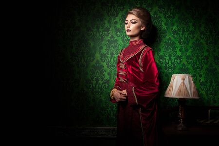 Rich woman dressed vintage clothes in retro interior. Rococo period. Luxury and high classの写真素材