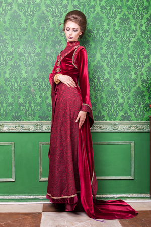 Charming woman dressed vintage clothes in retro interior. Rococo period. Luxury and high classの写真素材