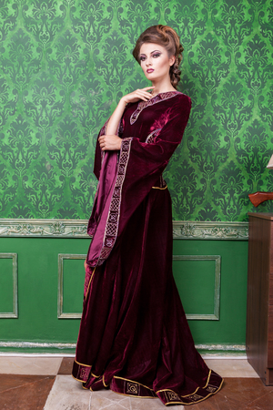 Charming woman dressed in vintage clothes in retro interior. Rococo period. Luxury and high classの写真素材