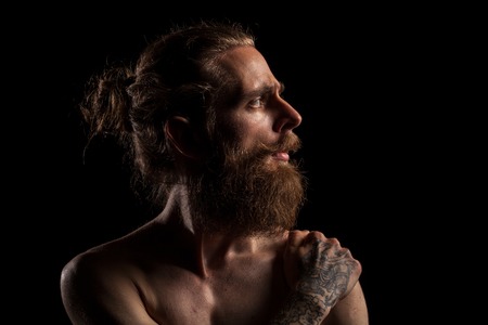 Cool bearded hipster on black background in studio photo. Expression and fashionの写真素材