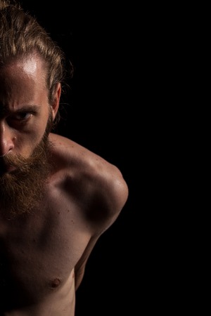 Portrait of bearded cool hipster on black background in studio photo. Expression and fashionの写真素材