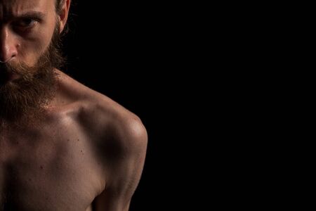 Portrait of bearded cool hipster on black background in studio photo. Expression and fashion