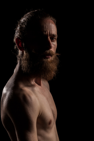 Portrait of bearded guy on black background in studio photo. Expression and fashionの写真素材