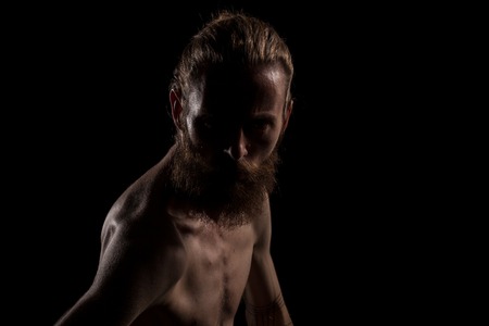 Angry hipster in dramatic photo on black background in studio. Expression and fashionの写真素材