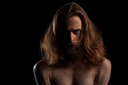 Hipster with long hair and beard on black backgroundin studio photo. Expression and fashionの写真素材