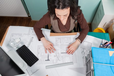Architect woman at her desk working on blueprints. Business and creativity. Architecture jobの写真素材