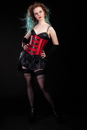 Sexy sensual woman in fetish leather corset on black background in studio photo. BDSM and dominatrixの写真素材