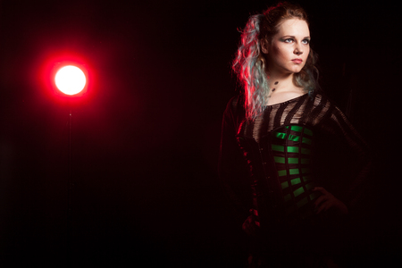 Sexy cosplay model in corset in studio photo with a red and green light from behind. Cosplay and subcultureの写真素材