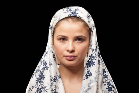 Russian woman wearing a headscarf on black background in studio photoの写真素材
