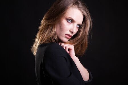 Portrait of woman in casual fashion clothes in studio photo on black background. Sexyality and sensualityの写真素材