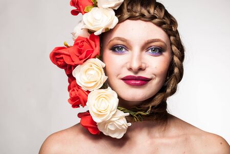 Smiling Woman with flowers arround her head in studio photo. Beauty and fashion. Glamour and summerの写真素材