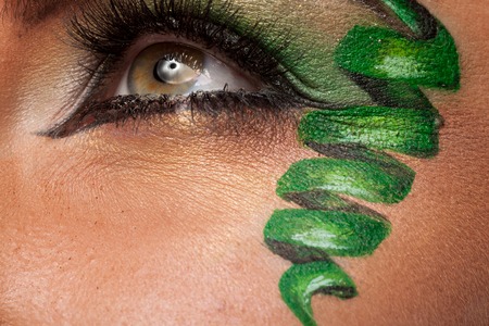 Close up of an eye with green artistic make up in studio photoの写真素材