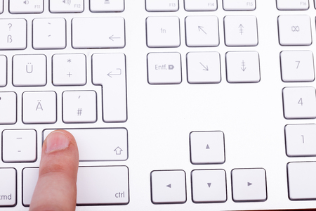 Finger pressing on keyboard key in close upの写真素材