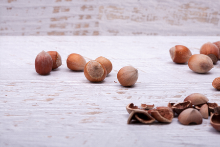Hazelnuts on white wooden background in studio photoの写真素材