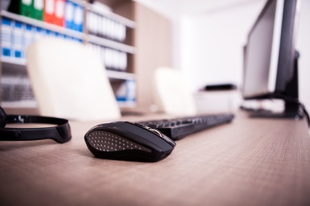 Close up of keyboard, mouse and headset on office table. Modern interior design