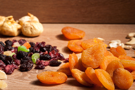 Mix of different dried fruits on wooden background. Healthy raw organic snackの写真素材