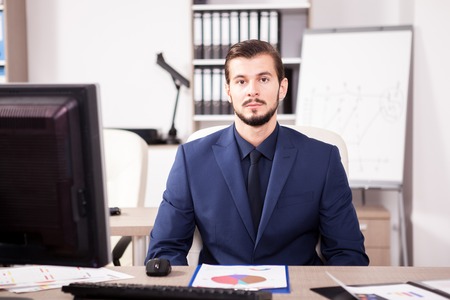 Businessman in suit working in his officeの写真素材