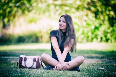 Pretty young woman posing in the park. Outdoor portrait. Fun and relaxationの写真素材