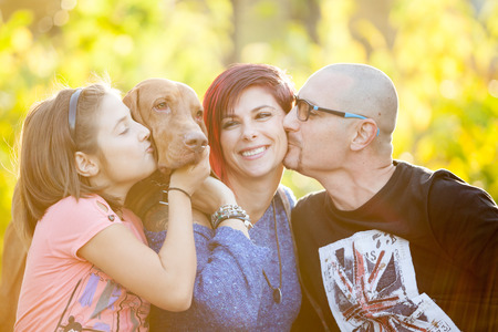 Beautiful family on the grass in park playing with their dog. Animal loversの写真素材