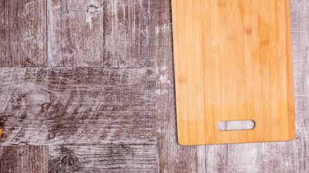 Empty cutting wooden plate on wooden background. Copy space availableの写真素材