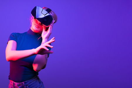 Woman touching a virtual button with VR set on her headの写真素材