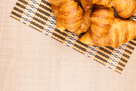 Top view on delicious fresh croissants of different sizes on a tableの写真素材