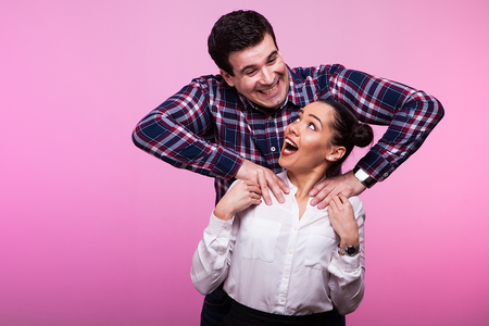 Adult couple in studio on pink background beeing sillyの写真素材