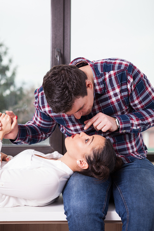 Beautiful woman in men laps lookign up at him. Love and happinessの写真素材