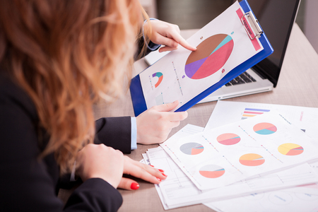 Close up of business woman hands poiting at a diagram on a boardの写真素材