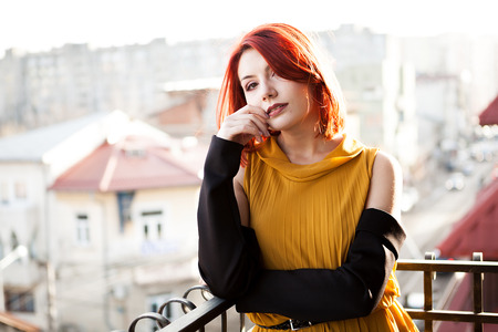 Outdoor portrait of beautiful redhead woman over city backgroundの写真素材