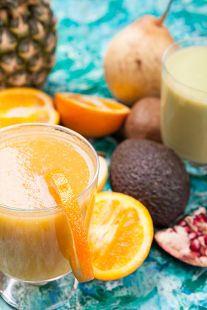 Glasses with detox smoothie surrounded by fruits it was made ofの写真素材